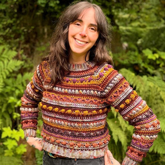 A crochet raglan sweater pattern featuring intricate stitch work, tapered sleeves, and colorwork. It contains many different stitches, making it fun to work up. It is an advanced level pattern in sizes XS-4X